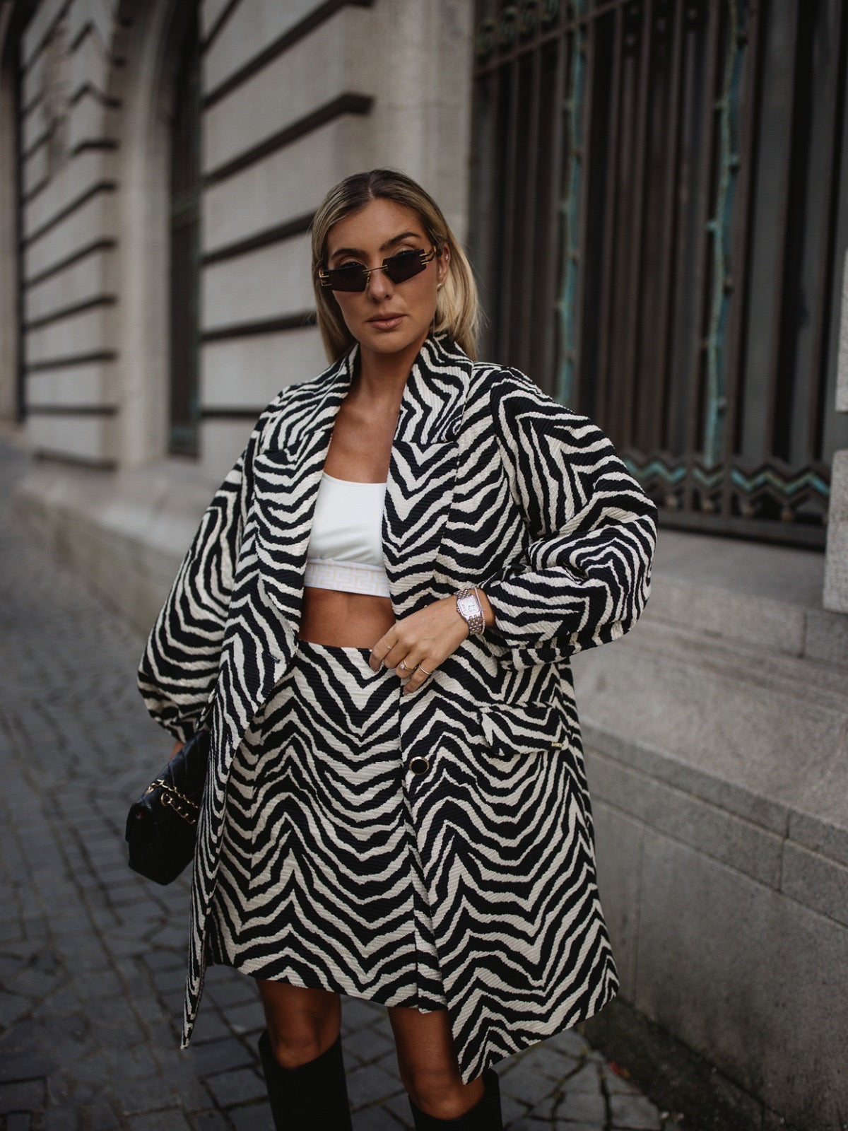 Manteau à motif zèbre chic blanc et noir. Col raffiné à rabat. Manches longues ballon avec plis élégants.